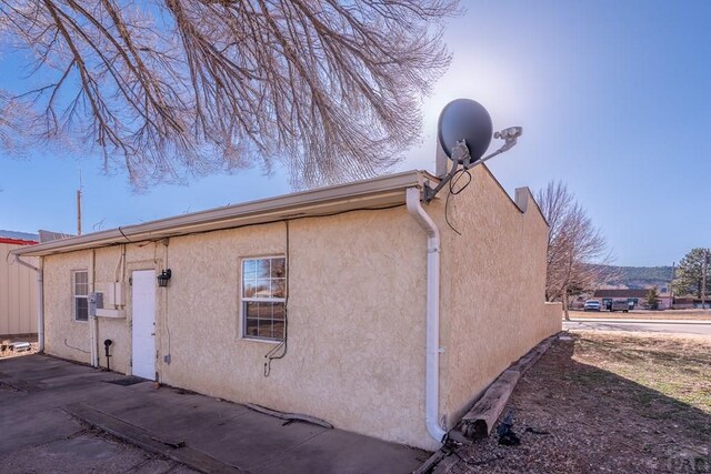 view of side of home with stucco siding