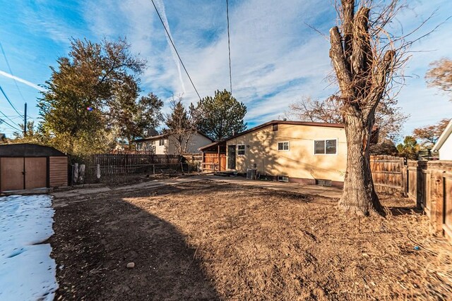 rear view of house with an outbuilding, a shed, and a fenced backyard