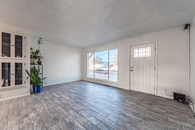 foyer with a textured ceiling and wood finished floors