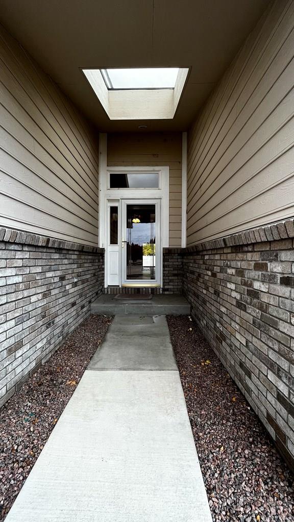 entrance to property featuring brick siding