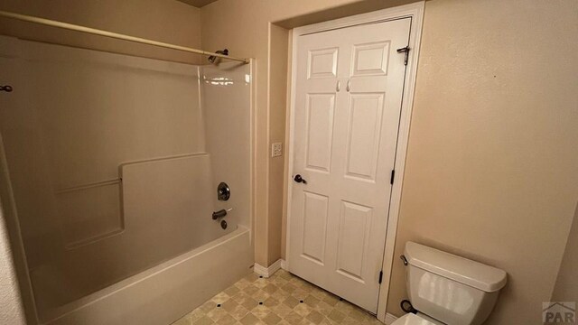 full bathroom featuring baseboards,  shower combination, toilet, and tile patterned floors