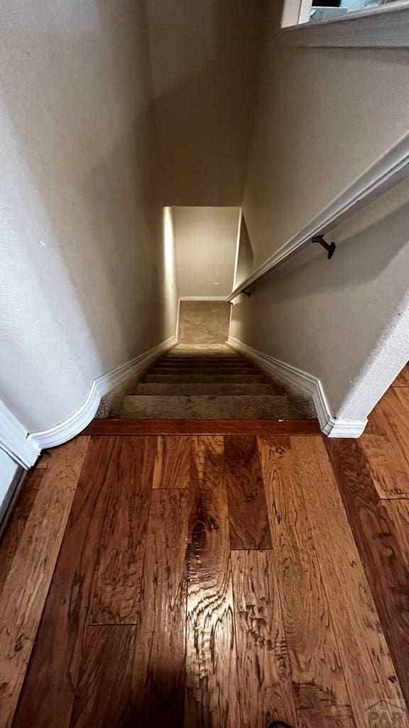 stairway featuring baseboards and wood finished floors