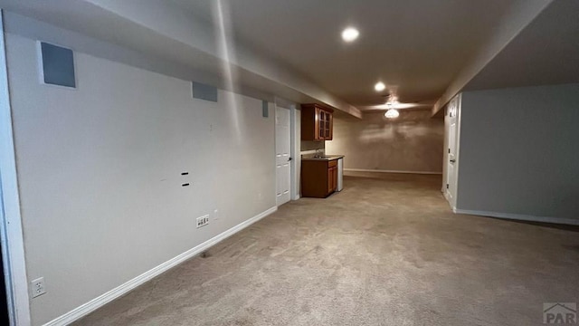 finished basement featuring baseboards and light colored carpet