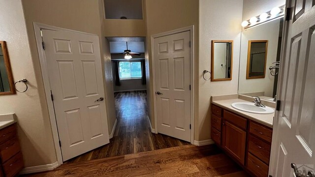 bathroom featuring ceiling fan, baseboards, wood finished floors, and vanity