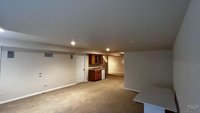 finished basement with recessed lighting, carpet, a sink, and baseboards