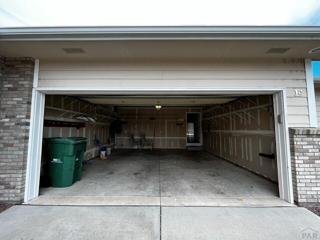 garage with concrete driveway and visible vents