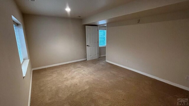 carpeted spare room with baseboards