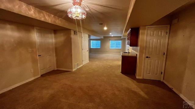 corridor featuring carpet, visible vents, baseboards, and a sink