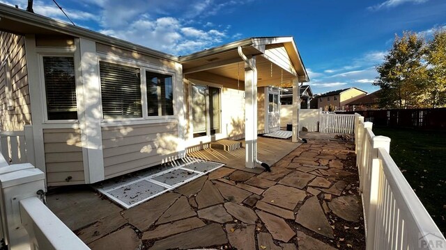 view of side of home with a patio area and fence