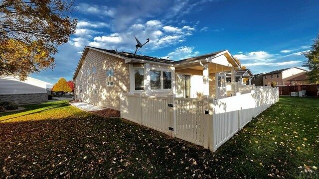 view of property exterior featuring a lawn and fence