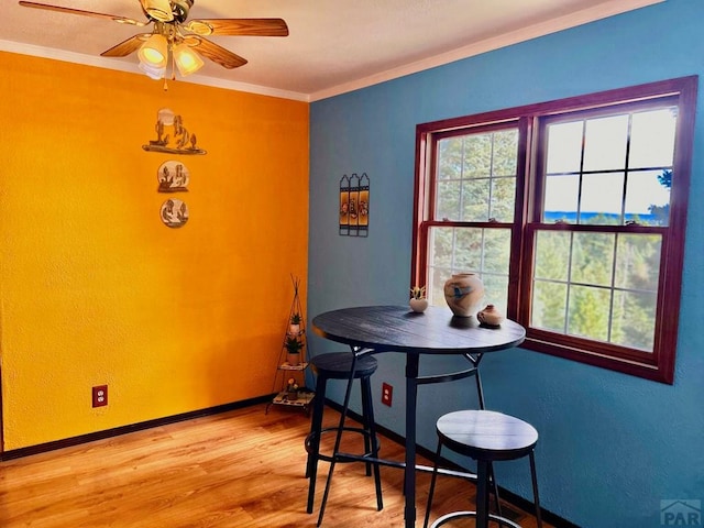 dining room featuring ornamental molding, wood finished floors, a ceiling fan, and baseboards