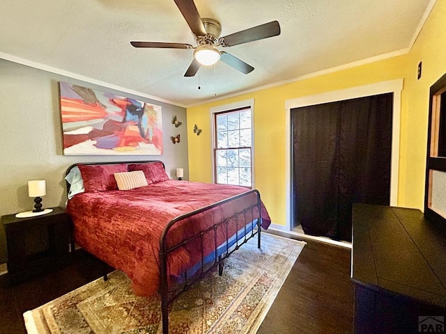 bedroom featuring a textured ceiling, ornamental molding, and a ceiling fan