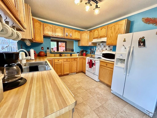 kitchen with light countertops, a sink, a textured ceiling, white appliances, and under cabinet range hood