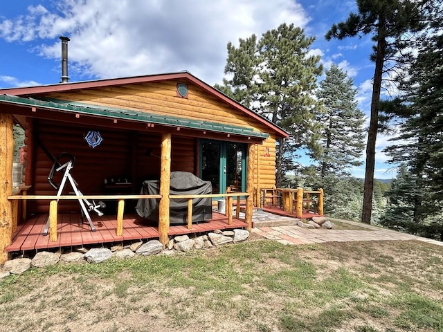 rear view of property featuring a wooden deck