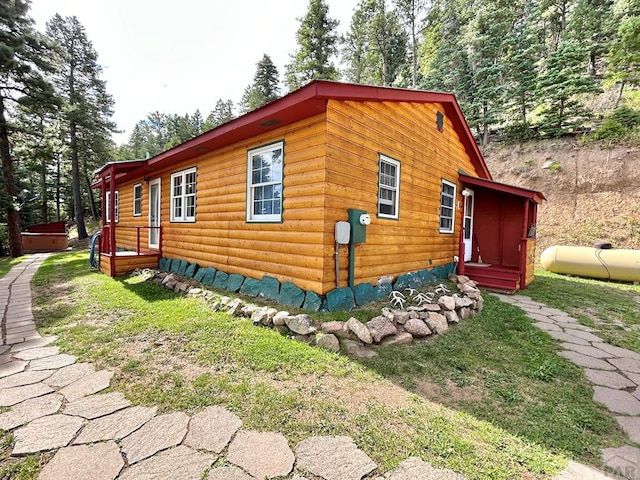 view of side of property with a hot tub and faux log siding