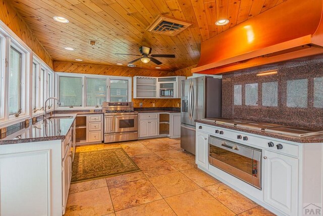 kitchen with visible vents, white cabinets, appliances with stainless steel finishes, extractor fan, and a sink