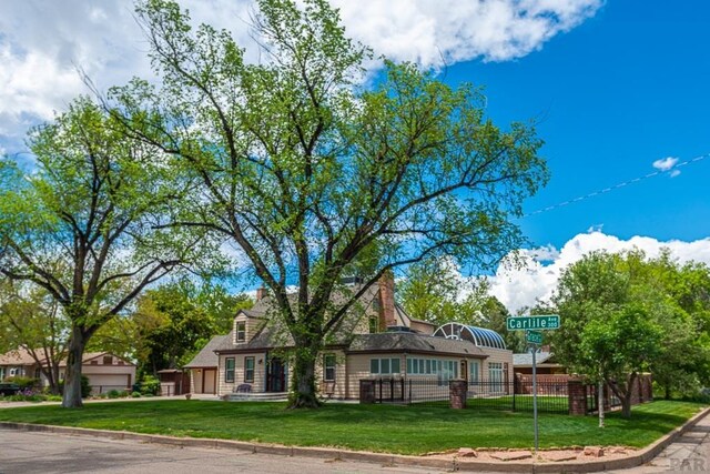 view of front of property featuring a chimney, a front yard, and fence