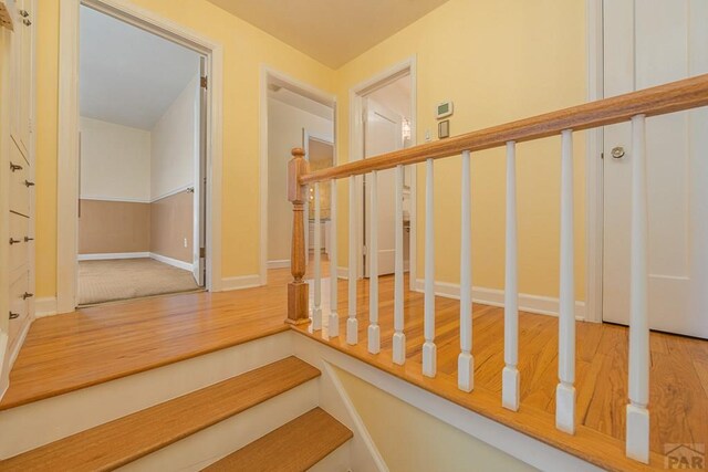 staircase featuring baseboards and wood finished floors