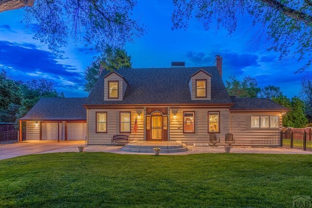 view of front of house featuring a chimney, a shingled roof, concrete driveway, a lawn, and fence