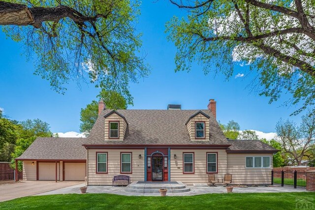 cape cod house featuring driveway, a garage, a chimney, roof with shingles, and fence