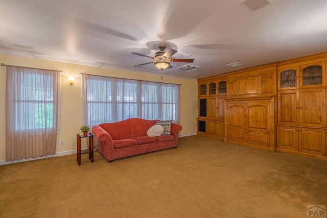 living room with light carpet, a ceiling fan, visible vents, and crown molding