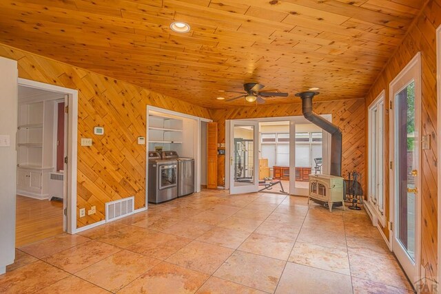 spare room featuring radiator, visible vents, wood ceiling, a wood stove, and independent washer and dryer