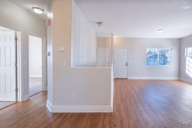 spare room featuring baseboards and wood finished floors