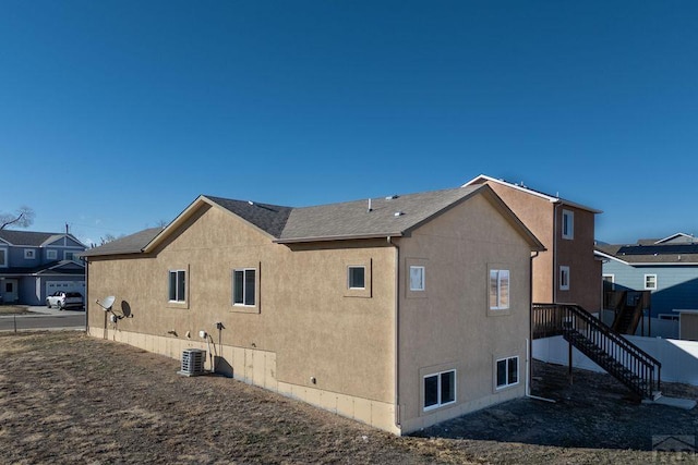 view of side of home with cooling unit and stucco siding