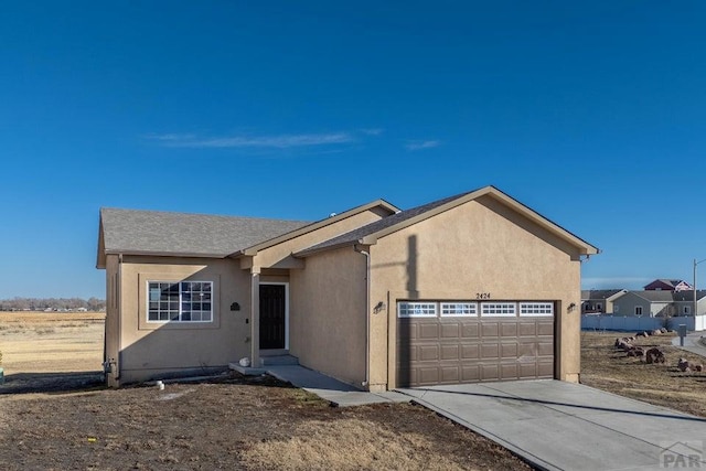 view of front of property featuring an attached garage, concrete driveway, and stucco siding