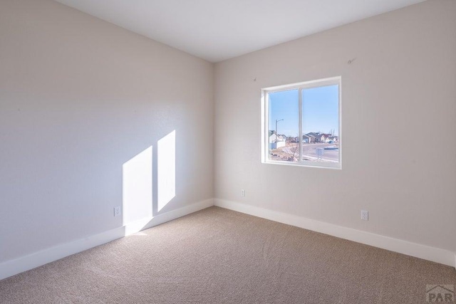 carpeted empty room with baseboards