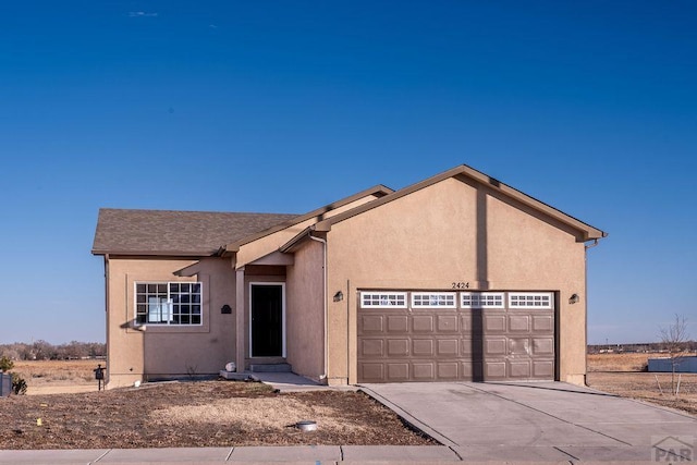 view of front of home with an attached garage, concrete driveway, and stucco siding