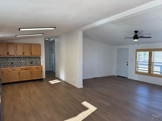 kitchen with dark wood finished floors, backsplash, open floor plan, ceiling fan, and a textured ceiling