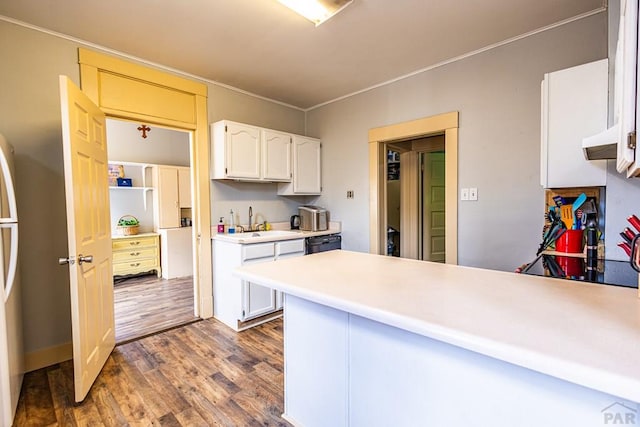 kitchen with a peninsula, white cabinetry, light countertops, and a sink