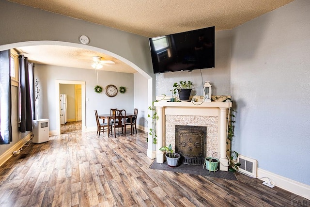 living area featuring a textured ceiling, wood finished floors, and visible vents