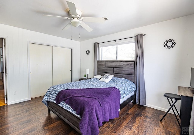 bedroom featuring a closet, dark wood-style flooring, ceiling fan, and baseboards