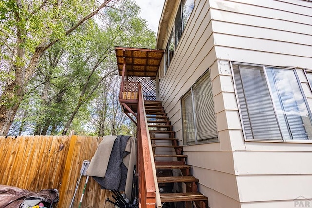 view of home's exterior featuring stairway and fence