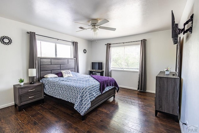 bedroom with a ceiling fan, dark wood finished floors, and baseboards