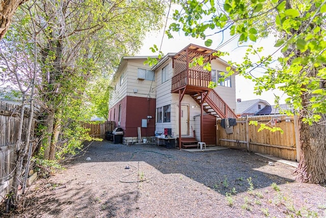 back of property with stairs, a fenced backyard, and entry steps