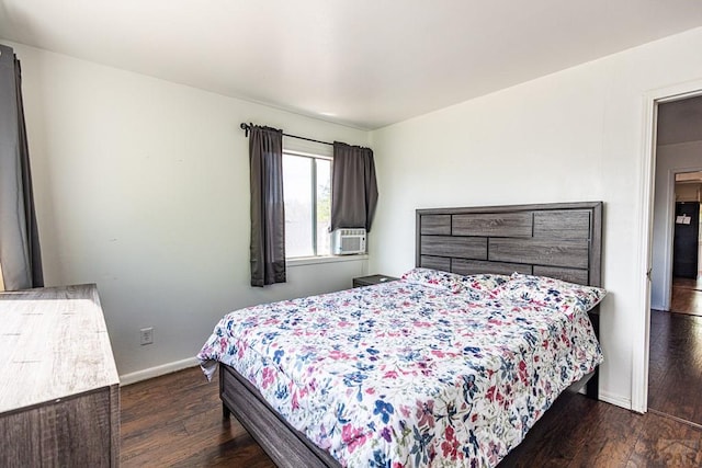 bedroom featuring baseboards and dark wood-style flooring