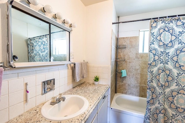 bathroom with backsplash, shower / bath combo with shower curtain, vanity, and tile walls