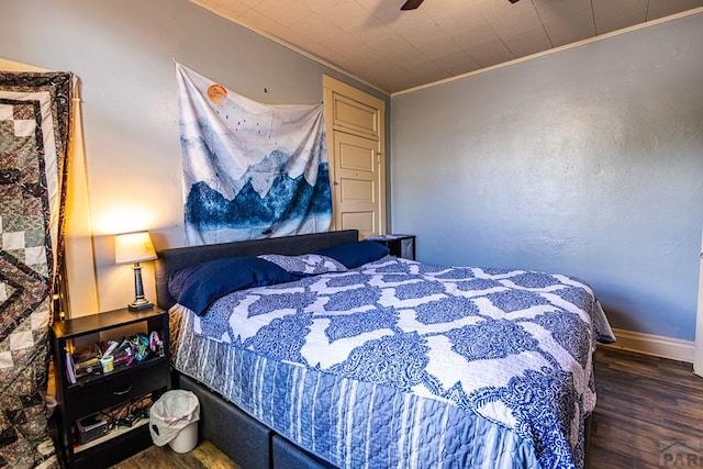 bedroom featuring ceiling fan, ornamental molding, dark wood finished floors, and baseboards