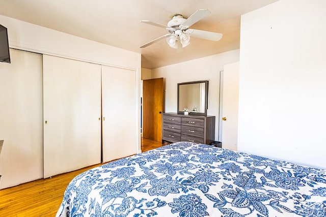 bedroom with light wood-style floors, a closet, and ceiling fan