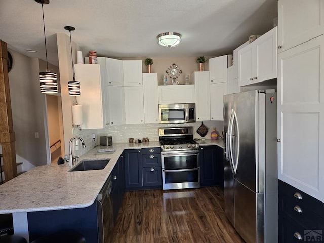 kitchen with a sink, light stone counters, stainless steel appliances, decorative backsplash, and dark wood-style flooring