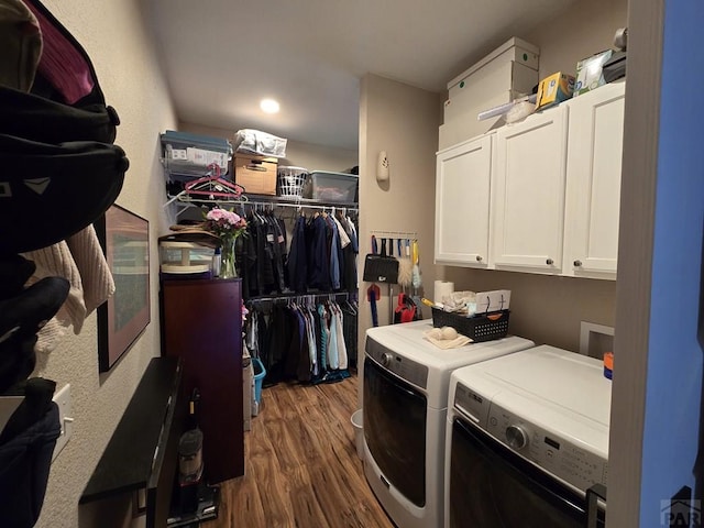 washroom with dark wood finished floors, cabinet space, and washer and clothes dryer