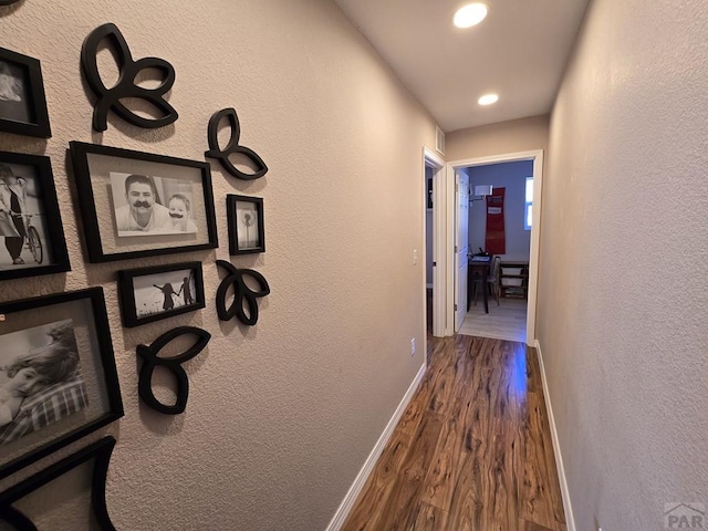 hallway with recessed lighting, baseboards, dark wood-style floors, and a textured wall