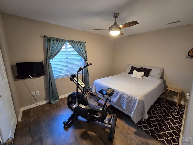 bedroom featuring baseboards, wood finished floors, visible vents, and ceiling fan