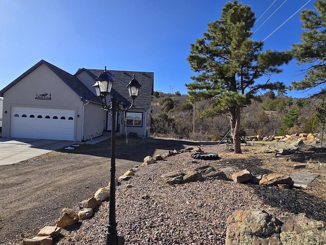 view of front of home with concrete driveway, a garage, and stucco siding