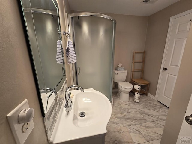 bathroom with visible vents, toilet, marble finish floor, a stall shower, and a sink