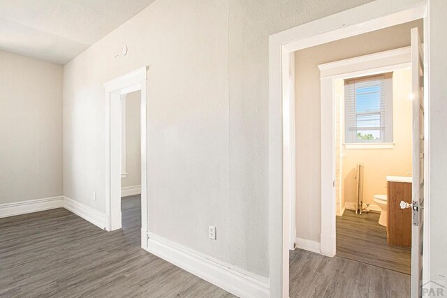 empty room featuring dark wood-style floors and baseboards