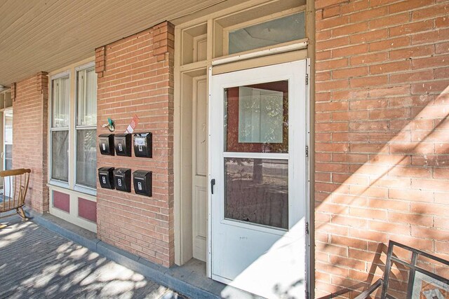 property entrance featuring brick siding